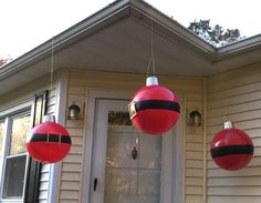 red and black ornaments hanging from the side of a house