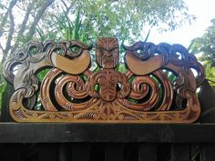 an intricately carved wooden bench sitting in front of trees