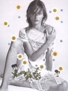 a black and white photo of a woman with sunflowers