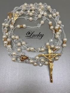 Balanced mix of Ivory Pearls and crystal beads attached to a classic crucifix (Choice of Gold or Silver Cross) by Lucky Collections ™. Available on www.ProBridalUSA.com *High-quality Crystals and Ivory Pearls, Silver-Gold Plated Cross *Handmade with Love *The Lasso has two loops. Each loop fits one person. * Safekeep the memorable moment of Lasso Unity Ceremony in a lasso box also designed by Lucky Collections™ * Ideal for Spanish Catholic Wedding, Hispanic Anniversary, Wedding gift, Anniversary Elegant Pearl Rosary With Round Beads, Elegant Pearl White Rosary With Round Beads, Elegant White Pearl Rosary, Elegant Pearl White Pearl Rosary, Elegant Beaded Rosary, Elegant Beaded Wedding Rosary, Elegant Beaded Rosary With Round Beads, Wedding Silver Pearl Rosary, Elegant Pearl Beaded Rosary