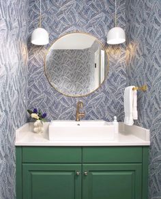 a bathroom sink with a mirror above it and lights hanging from the ceiling over it