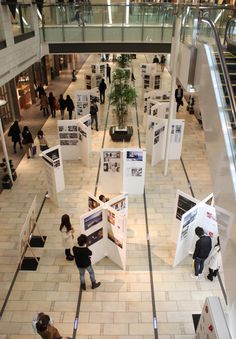 an overhead view of people walking around in a building with posters on the walls and stairs