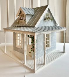 a doll house with flowers on the roof