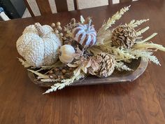 a wooden tray filled with pine cones and other decorations