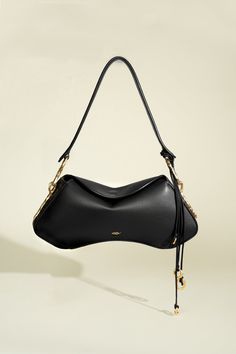 Distinguished by its hourglass silhouette, the Deià bag is handcrafted in Spain and features a structured frame and soft, fold-over flap with magnetic closure. Its timeless form is accented by hand-tooled 24k gold-plated hardware with irregular contours echoing nature’s organic elegance. The spacious interior is lined with soft cotton twill and contains a convenient leather pocket. This version is made from buttery soft Italian nappa leather and features a wide leather shoulder strap. It is orna Organic Gold Ring, Body Decor, Luxury Bags Collection, Hourglass Silhouette, Organic Rings, Cute Bags, Nappa Leather, Mode Outfits, Leather Cord