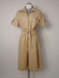 Vintage jumpsuit with bermuda pants, zip on the front, short sleeve. The fabric is a light cotton, colour sand, in very good condition Measure Shoulder cm 39 Bust cm flat 48 Waist cm flat without belt 42 Hip cm flat 49 Total lenght cm  106 Vintage Cotton Jumpsuits With Short Sleeves, Vintage Cotton Short Sleeve Jumpsuits And Rompers, Vintage Cotton Jumpsuits And Rompers With Short Sleeves, Short Sleeve Khaki Jumpsuits And Rompers With Pockets, Khaki Short Sleeve Jumpsuits And Rompers With Pockets, Khaki Short Sleeve Jumpsuit With Pockets, Beige Short Sleeve Jumpsuits And Rompers For Spring, Cream Short-sleeved Jumpsuit For Spring, Spring Khaki Short Sleeve Jumpsuits And Rompers