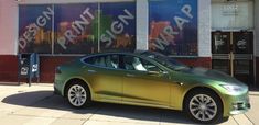 a green car parked in front of a building