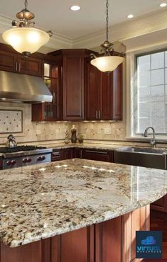 a large kitchen with granite counter tops and wooden cabinets, along with an island in the middle