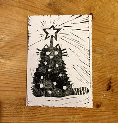 a drawing of a christmas tree on top of a wooden table with a star above it