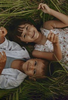 two young children laying in the grass together