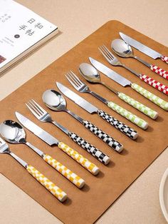 there are many different types of spoons and forks on the table next to each other