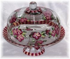 a glass covered dish with pink flowers on it