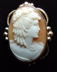 Exquisitely carved shell cameo set into 14kt frame. The intricate details in the hair ringlets, and the pearl necklace show the quality carving from the artist. It is marked 14kt and there is a makers mark that I cannot make out.  The details date this cameo to the 1930's and it is in excellent condition, see pictures.  1" x 3/4" Antique Cameo Jewelry For Anniversary, Victorian Cameo Jewelry For Anniversary, Antique Cameo Yellow Gold Jewelry, Antique Yellow Gold Cameo Jewelry, Victorian Baroque Collectible Jewelry, Antique Oval Cameo Jewelry, Victorian Cameo Round Jewelry, Victorian Round Cameo Jewelry, Ornate Cameo Jewelry For Formal Occasions