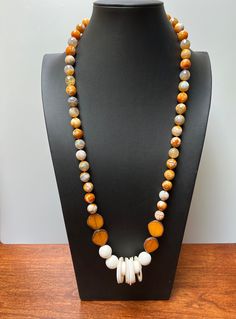 ORANGE SPICE:  LOOOOooooong necklace statement piece.  Agate orange/white beads.  Focal point of glass beads with lava bead texture in white with white shell loops.  The loops sometimes bunch in the center or spread themselves across the lava beads.  The four orange irregular coin beads are Premium Picasso Czech glass.   I imagine this on a white dress but the complement of orange is blue, particularly denim is awesome. If you wish a longer or shorter necklace, please ask.  $3 charge for changes White Agate Jewelry With Polished Beads, White Agate Necklace With Round Beads, White Artisan Long Necklace, White Agate Necklace For Jewelry Making, Artisan White Necklaces With Natural Stones, White Hand-strung Long Necklace Beads, White Hand-strung Long Bead Necklace, White Gemstone Beads Long Necklace, White Long Necklace With Natural Stones