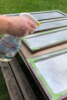 a person is spray painting some wood with green paint on the top and bottom half