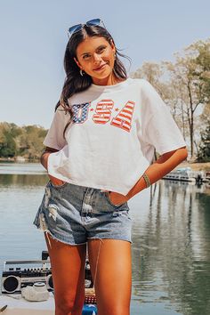 - Time for cocktails and sparklers with this adorable USA tee! - Unlined material with a red and navy blue 'USA' graphic design on the front - A crew cut neckline - Short, loose sleeves - A relaxed silhouette that ends in a straight hemline Boutique Tees, Usa T Shirt, Usa Tee, Patriotic Shirt, Crew Cut, Loose Sleeves, Usa Print, Usa Shirt, Crew Cuts