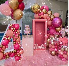 a pink and gold themed birthday party with balloons, cake, and decorations in the shape of letters