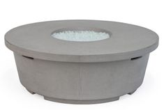 an outdoor concrete fire pit with white sand in the center and water coming out of it