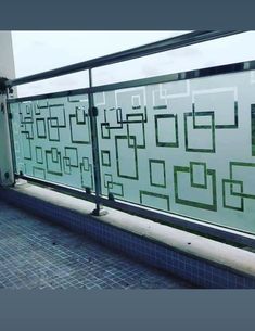 a balcony with tiled flooring and glass railings on the side of an apartment building