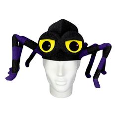 a spider hat with yellow eyes on top of a mannequin's head