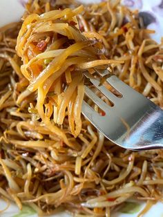 a fork that is in some food on a plate