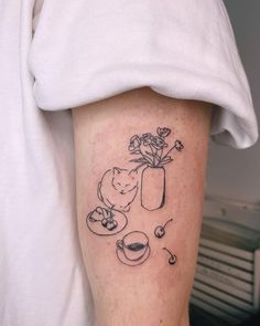 a person with a tattoo on their leg and some flowers in a vase next to it