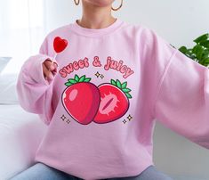 PLEASE NOTE:  This is an adult UNISEX hoodie.  If you want an oversized look then consider ordering up a size. This kawaii strawberry sweater will look very cute on you!   There are no side seams. A kangaroo pocket hangs in front. The hood's drawstring is the same color as the base sweater.  .: 50% cotton, 50% polyester .: Medium-heavy fabric (8.0 oz/yd² (271 g/m .: Classic fit .: Tear-away label .: Runs true to size Kawaii Pink Crew Neck Hoodie, Pink Kawaii Hoodie With Letter Print, Cute Relaxed Fit Hoodie With Crew Neck, Strawberry Sweatshirt, Fruit Sweater, Strawberry Clothes, Strawberry Sweater, Star Wars Sweater, Strawberry Aesthetic