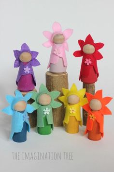 a group of wooden dolls sitting next to each other on top of a tree stump