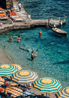 people are swimming in the clear blue water