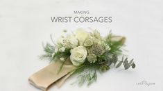 a bouquet of white flowers and greenery on a table with the words manning wrist corsages