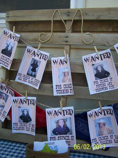 several wanted posters hanging on clothes pins