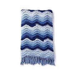 a blue and white crocheted blanket with fringes