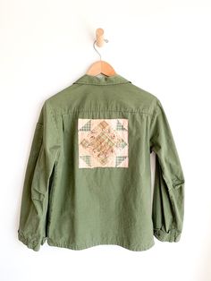 Upcycled cotton lightweight army jacket. Embellished at back and pockets with 1930’s quilt remnants. Fabric: Cotton poplinLabel: Sweet-Orr & CoFit: S/MEra: 1960/70’s Measurements: Bust 40" Shoulder 16.5" Sleeve 23" Length 26.5" Waist 39" Condition: Very good. Several tiny yellow paint specs on right front pocket flap. Retro Cotton Outerwear With Patches, Quilted Cotton Utility Jacket With Long Sleeves, Cotton Button-up Outerwear With Patches, Cotton Patchwork Utility Jacket, Cotton Patchwork Utility Jacket With Long Sleeves, Cotton Utility Jacket With Patchwork, Retro Khaki Cotton Utility Jacket, Vintage Cotton Button-up Utility Jacket, Vintage Quilted Cotton Outerwear