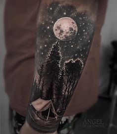 a man's arm with a tent and trees under the moon tattoo on it