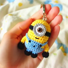 a crocheted minion keychain is being held in someone's hand