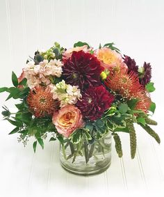 a vase filled with lots of flowers on top of a table