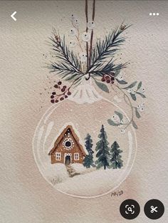 a watercolor christmas ornament with a house in the snow and pine trees