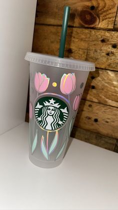 a starbucks cup with a green straw in it