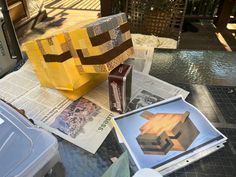 a bag made out of newspaper sitting on top of a table next to other items