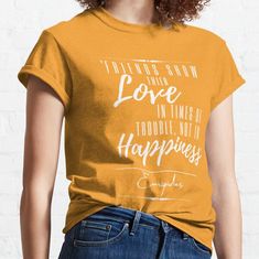 a woman wearing an orange t - shirt that says i always show love in times of trouble, not happiness