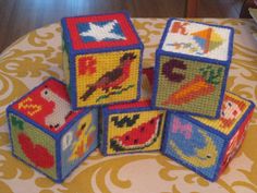 four colorful blocks with pictures of birds and other animals on them sitting on a table