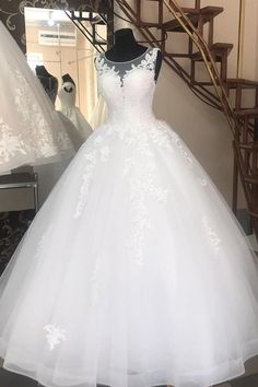 a white wedding dress on display in front of a mirror