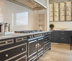 a large kitchen with stainless steel appliances and wood flooring is pictured in this image