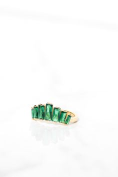 A crown ring featuring baguette cut emerald green cz. It is beautiful worn on its own and also stacked with other rings. Named for the Tiara given to Queen Alixandra at the turn of the century and later worn by Queen Elizabeth, each piece in this collection is a cheeky nod to the royals. Green Baguette Cut Stackable Rings, Green Emerald Stackable Open Rings, Green Emerald Open Ring Stackable Rings, Green Emerald Stackable Ring With Baguette Cut, Green Baguette Cut Stackable Emerald Ring, The Royals, Turn Of The Century, Crown Ring, Natural Gifts