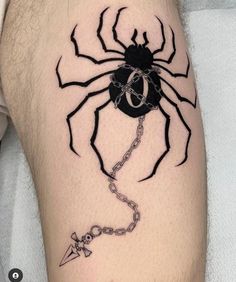 a black spider tattoo on the leg with a chain attached to it's legs