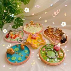 a table topped with lots of different shaped plates and trays filled with cake on top of them