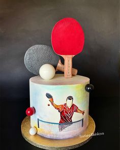 a cake decorated with a ping pong player and ball on it's side