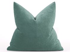 a green pillow sitting on top of a white surface