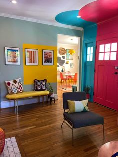 the living room is brightly colored and has chairs, tables, and pictures on the walls