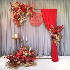 a red and gold wedding set up with flowers